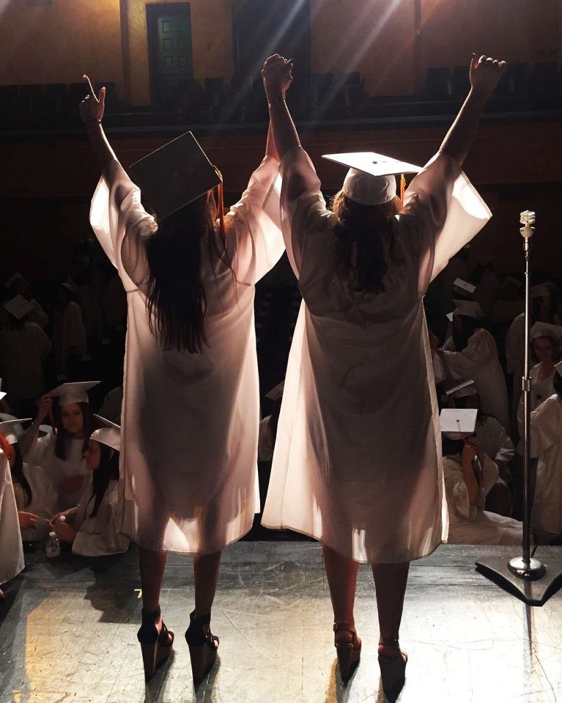 Graduate raising both hands